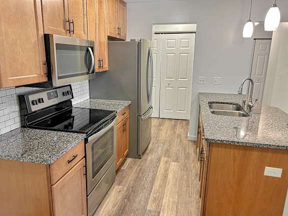 A kitchen with wooden cabinets and a granite countertop.