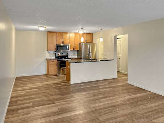 A kitchen with wooden floors and white walls.