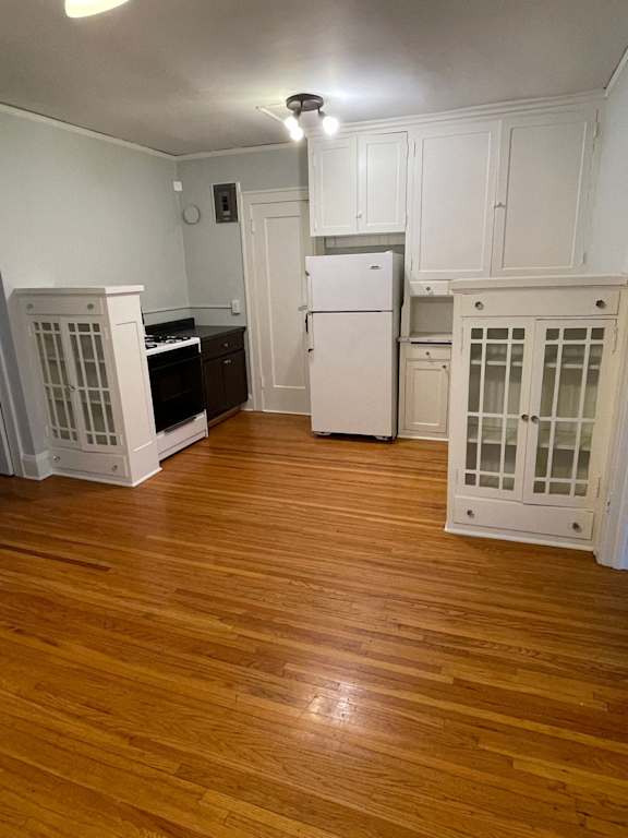A kitchen with white cabinets and a white fridge.