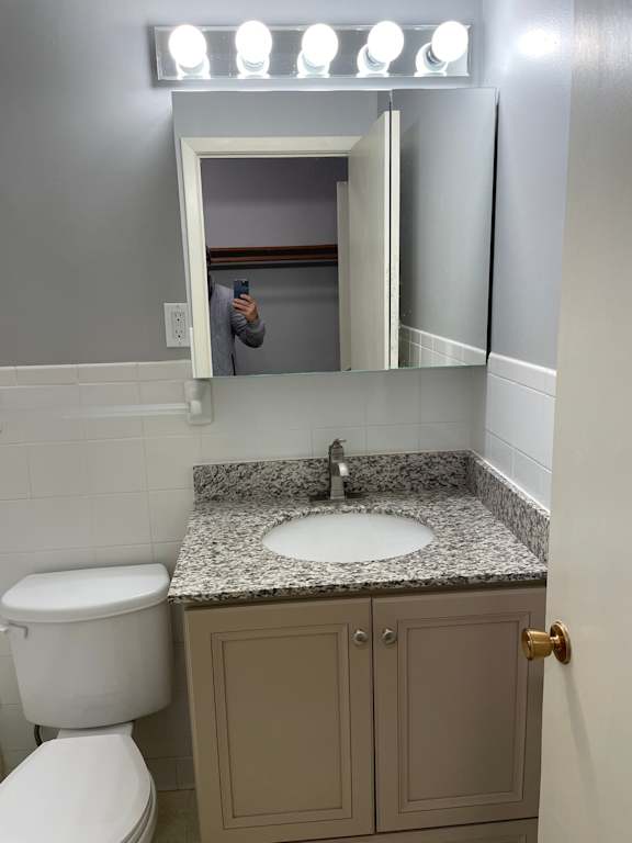 A bathroom with a sink, toilet and mirror.