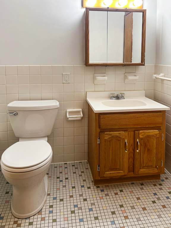 A white toilet sits next to a sink in a bathroom.