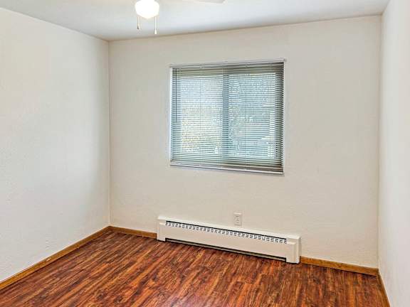 A room with a window and a radiator on the floor.
