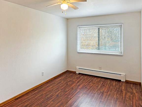 A room with a window and a ceiling fan.