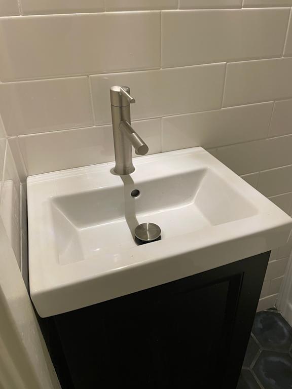 A white sink with a chrome faucet in a tiled bathroom.