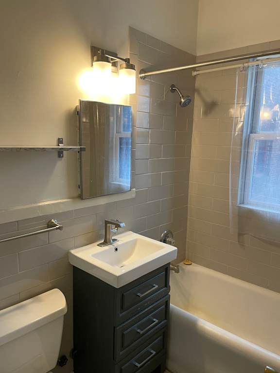 A white sink is on a black cabinet in a bathroom.