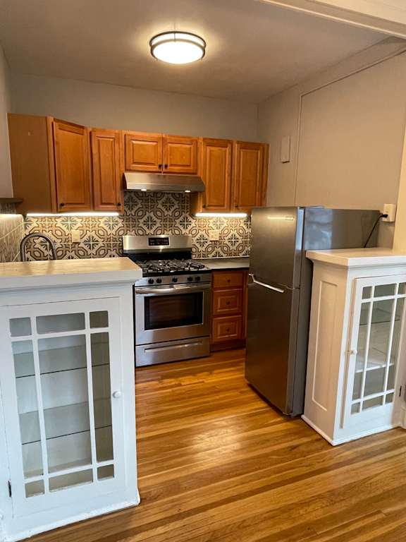 A kitchen with wooden cabinets and a white fridge.