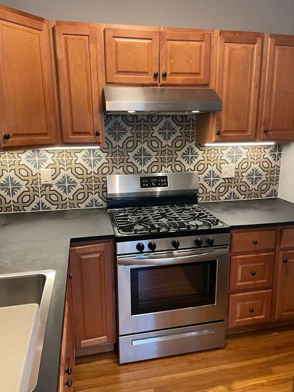 A kitchen with wooden cabinets and a stove top oven.