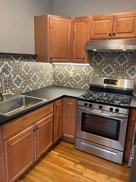 A kitchen with wooden cabinets and a stove top oven.