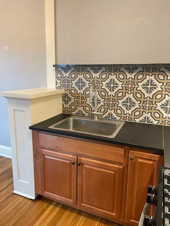 A kitchen with a sink and wooden cabinets.
