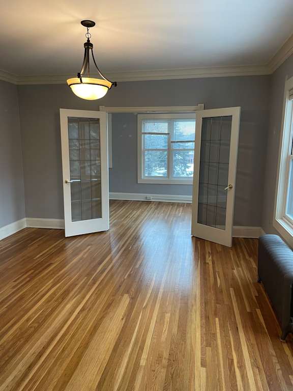 A room with wooden floors and a light hanging from the ceiling.