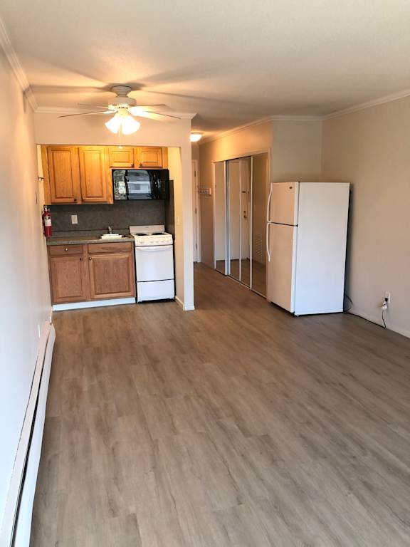 A kitchen with wooden cabinets and a white fridge.