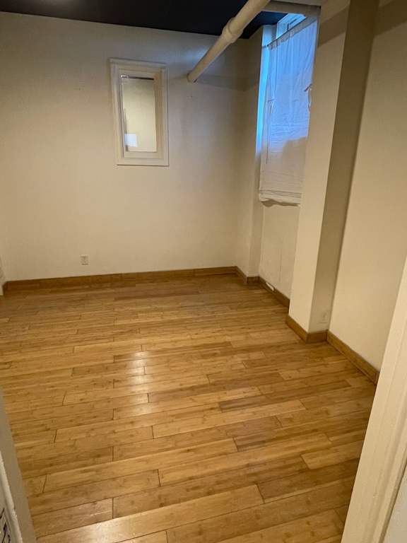 A room with wooden flooring and a mirror on the wall.