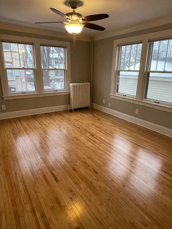 A room with wooden floors and a ceiling fan.