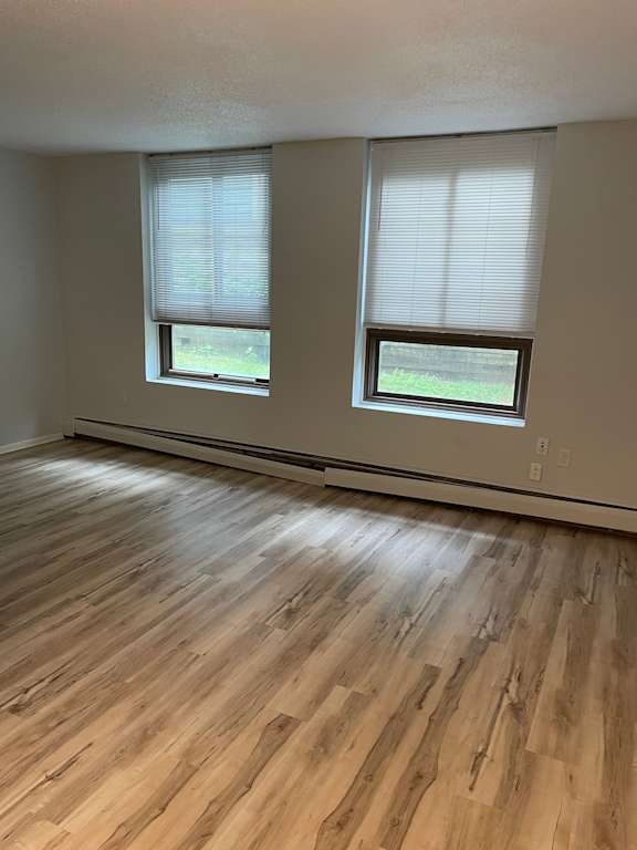 A room with wooden floors and two windows.