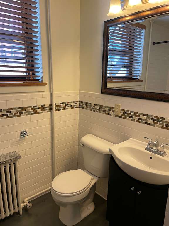 A white toilet sits next to a sink in a bathroom.