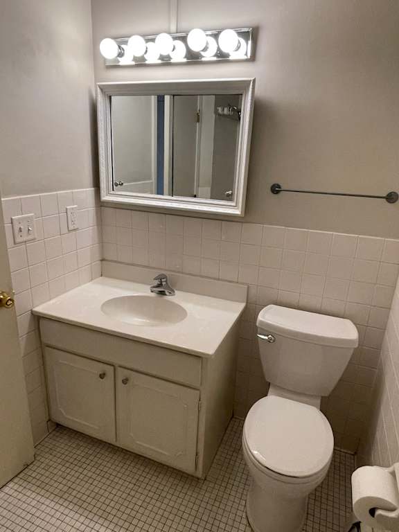 A white toilet sits next to a sink in a bathroom.