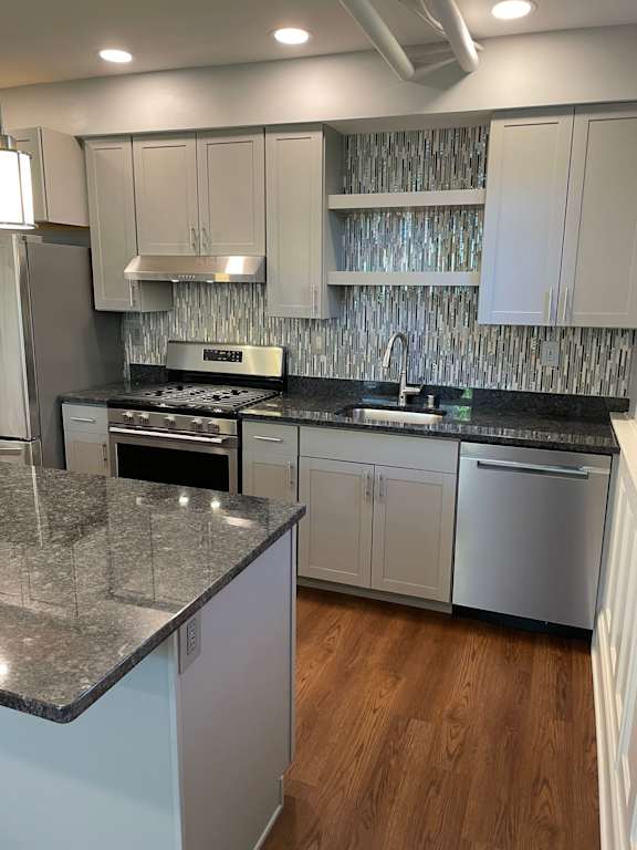 A kitchen with granite countertops and stainless steel appliances.