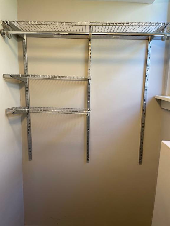 A metal shelving unit is mounted on a wall.