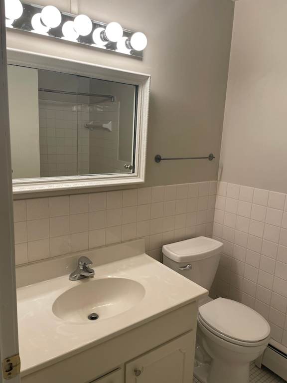 A white bathroom with a sink, toilet and mirror.