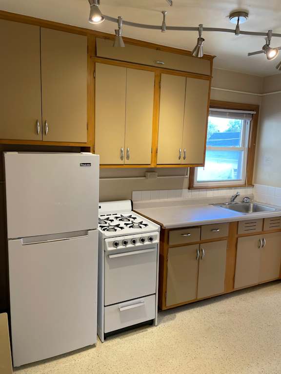 A kitchen with a white fridge and a white stove.