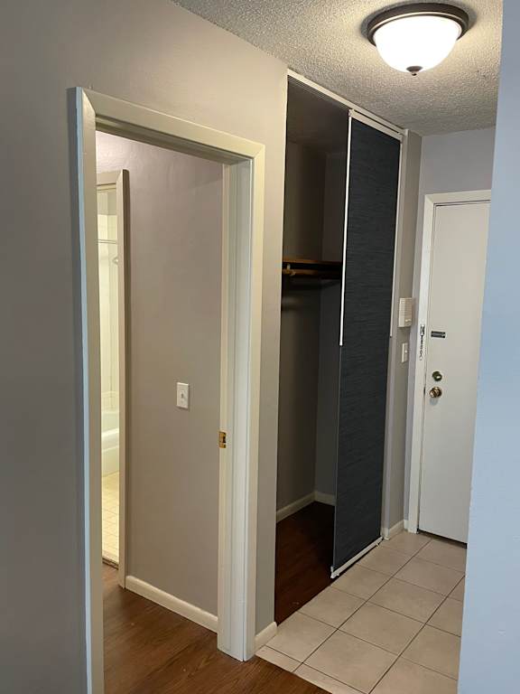 A hallway with a white door and a white wall.