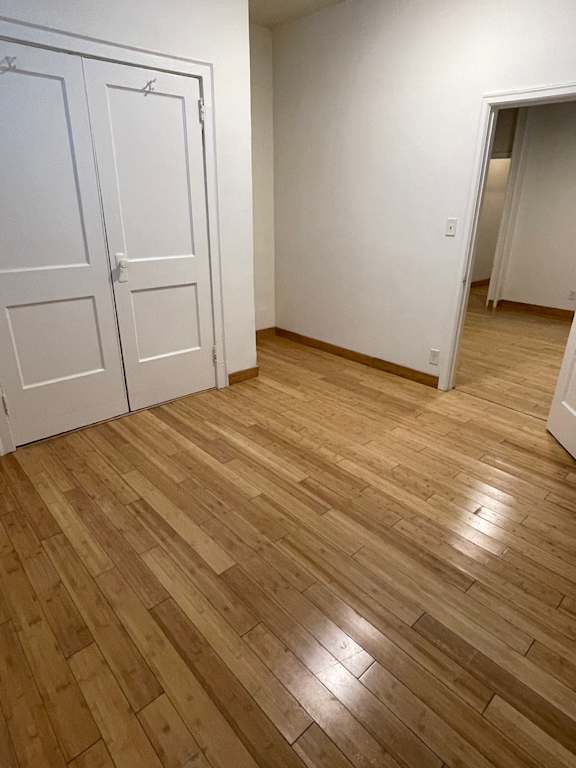 A room with a white door and a wooden floor.