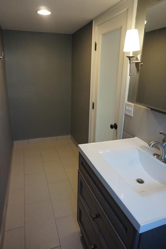 A bathroom with a white sink and a white door.