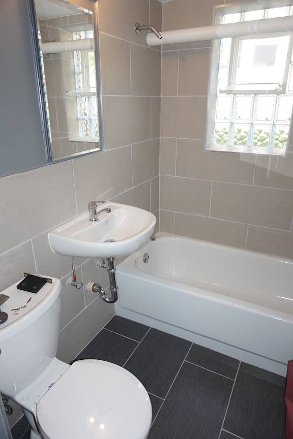 A white toilet sits next to a sink in a bathroom.