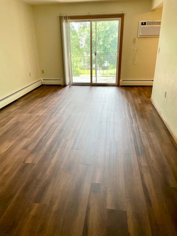 A room with wooden flooring and a sliding glass door.