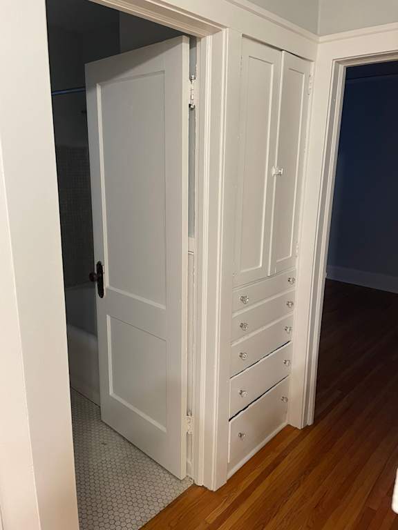 A white door with a handle and a set of drawers is open.