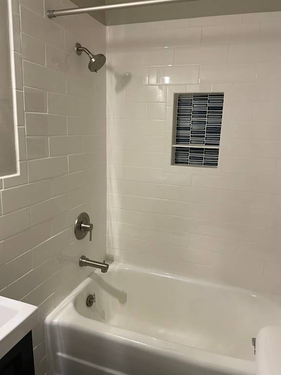 A white bathroom with a white tub and a white shower.