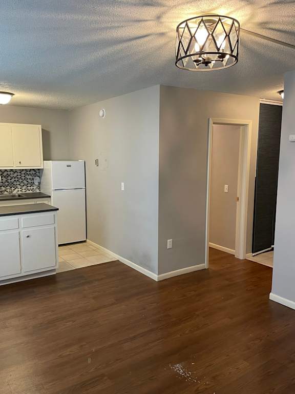 A kitchen with white cabinets and a black countertop.