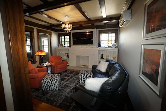 A living room with a fireplace and a zebra print rug.