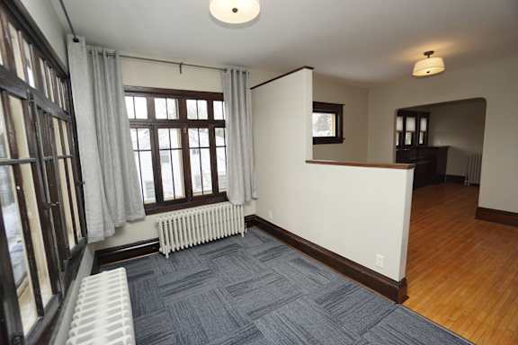 A room with a grey carpet and a white radiator.