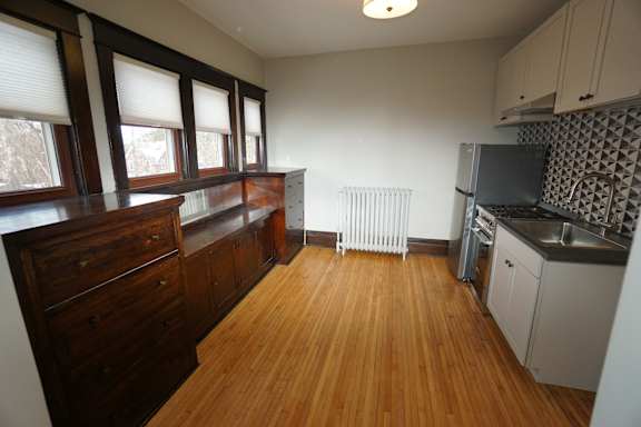 A kitchen with wooden floors and white walls.