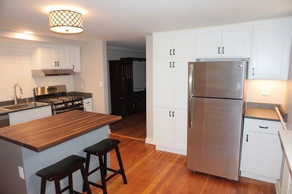 A kitchen with a wooden counter top and stainless steel appliances.