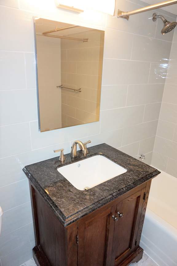 A bathroom sink with a counter and a mirror above it.