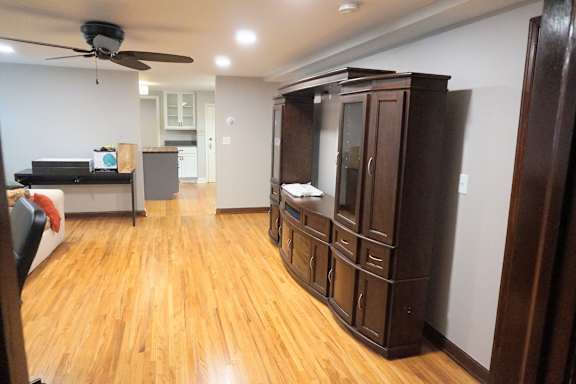 A room with wooden floors and a ceiling fan.