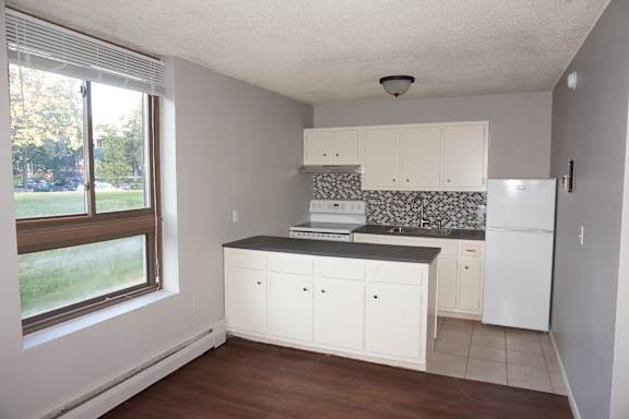 A kitchen with white cabinets and a black countertop.
