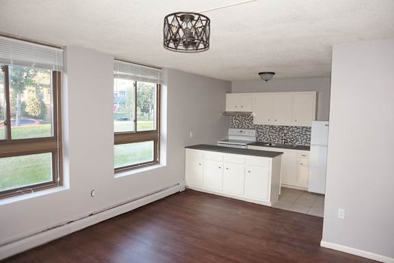 A kitchen with white cabinets and a black countertop.