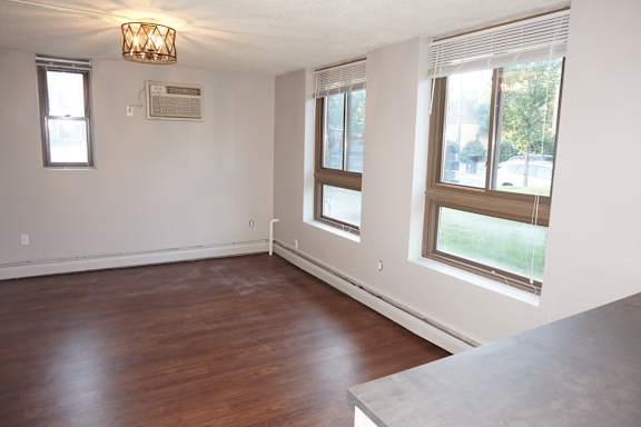 A room with wooden floors and a large window.