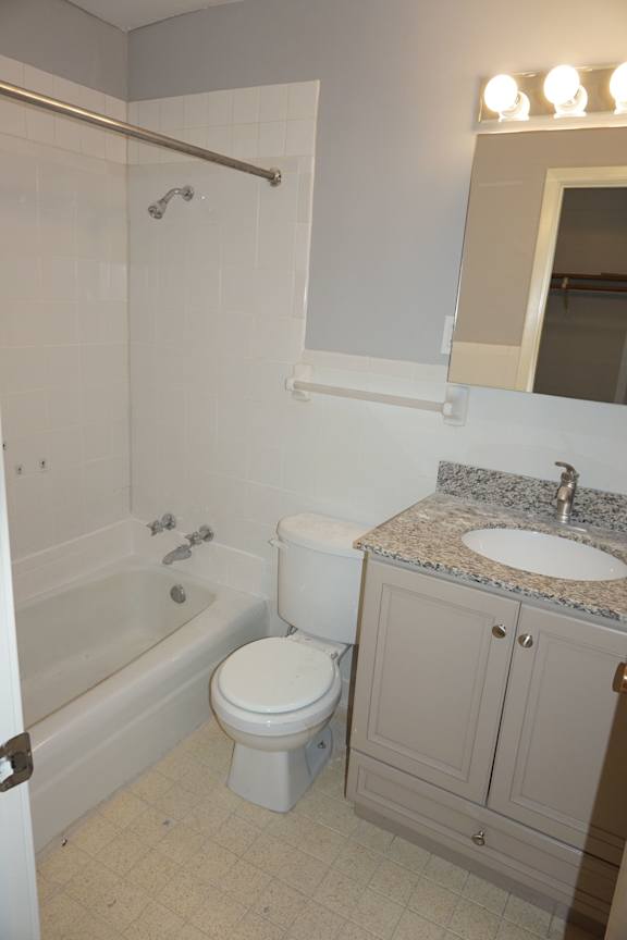 A white toilet sits next to a bathtub in a bathroom.