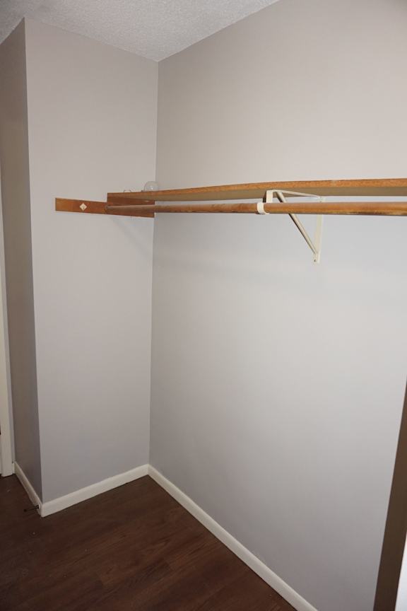 A white wall with a brown coat rack.