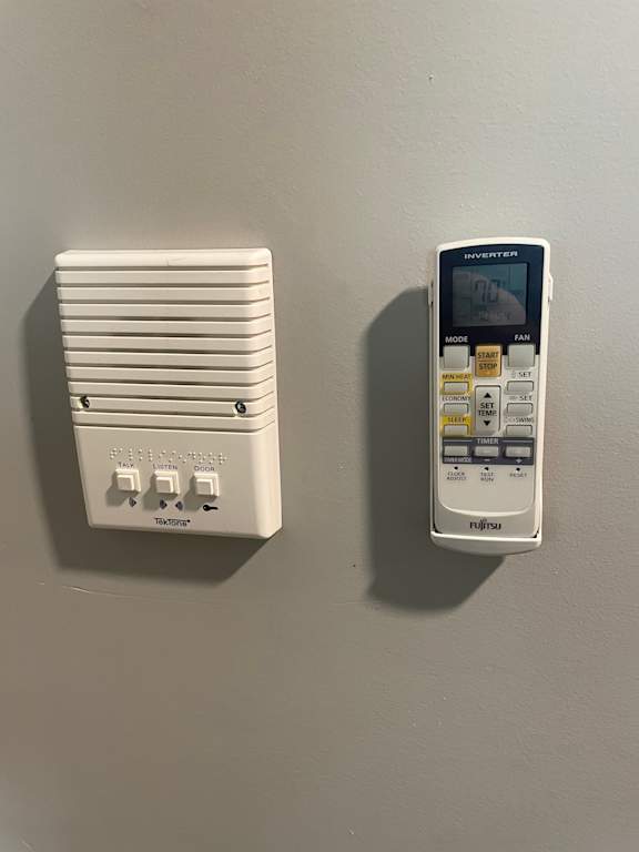 A wall-mounted thermostat and a handheld remote control.
