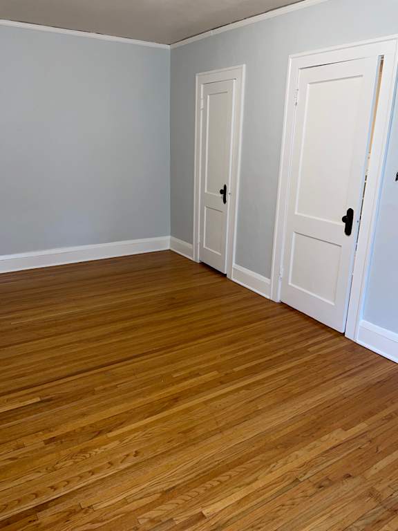 A room with two white doors and wooden flooring.