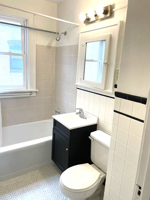 A white toilet sits in a bathroom next to a white sink.
