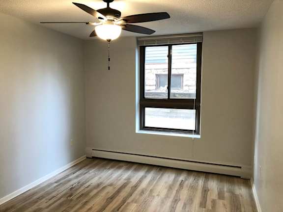A room with a ceiling fan and a window.