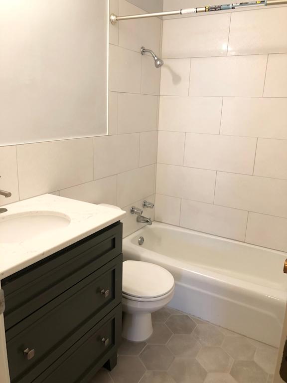 A white toilet sits next to a sink in a bathroom.
