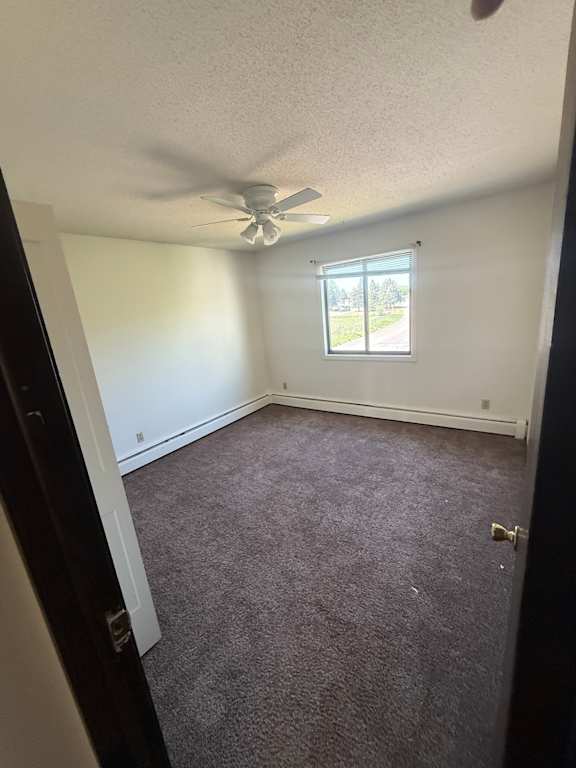 A small room with a window and a ceiling fan.