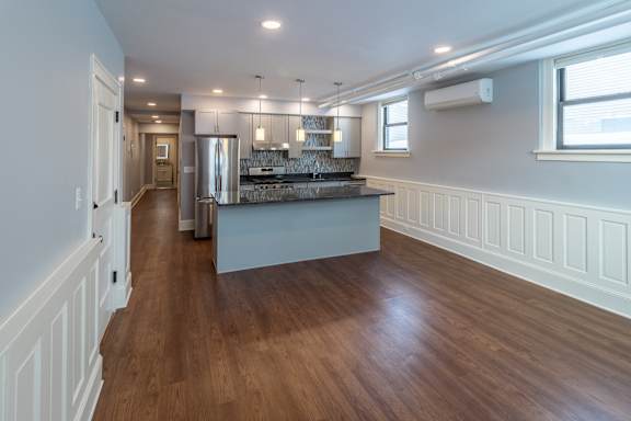 A kitchen with a wooden floor and white walls.